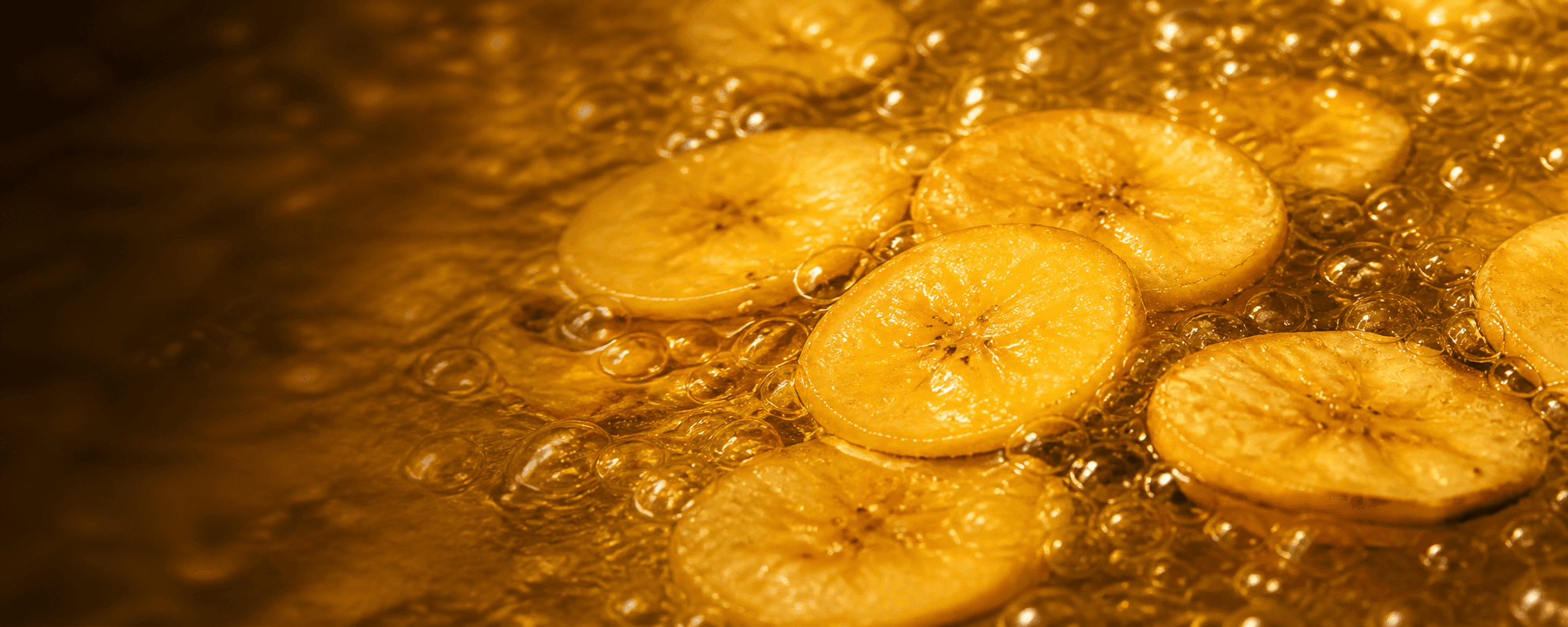 Plantain slices frying in bubbling coconut oil